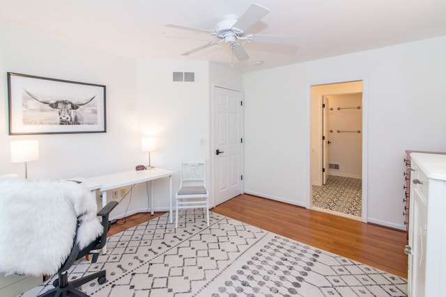 home office with light hardwood / wood-style floors and ceiling fan