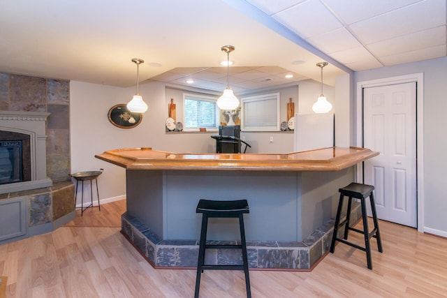 kitchen with pendant lighting, a breakfast bar, and light wood-type flooring