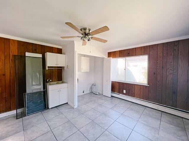 interior space featuring a baseboard heating unit, light countertops, wooden walls, and white cabinetry