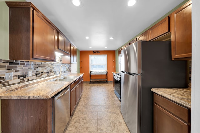 kitchen featuring sink, light stone countertops, stainless steel appliances, and tasteful backsplash