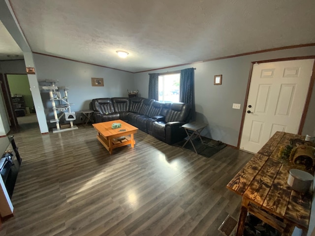 living room featuring dark hardwood / wood-style floors, ornamental molding, and a textured ceiling