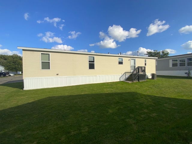 back of house featuring a yard and central AC