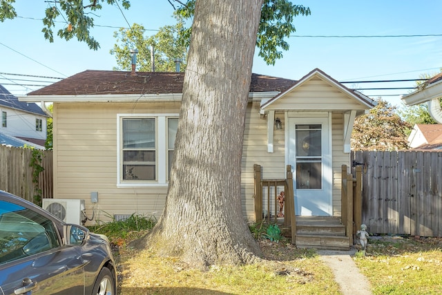 bungalow-style home with ac unit