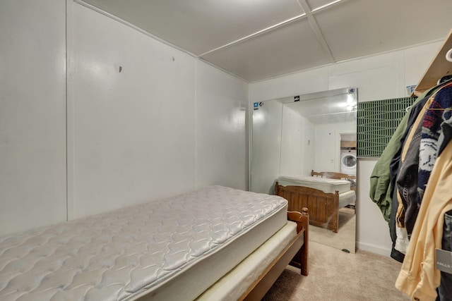 bedroom featuring light carpet and washer / clothes dryer