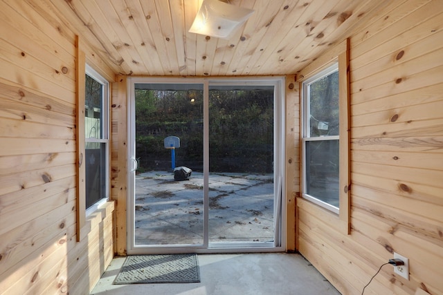 doorway to outside featuring a wealth of natural light, wooden ceiling, and wooden walls