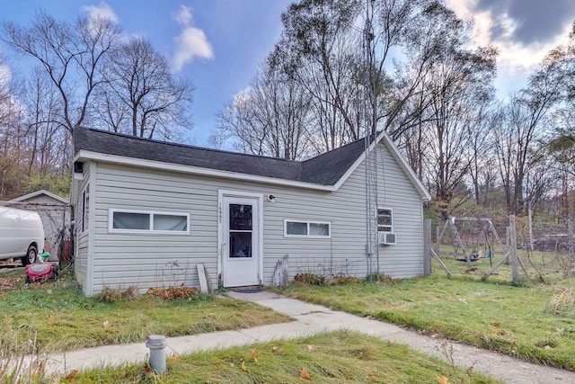 single story home featuring cooling unit and a front yard