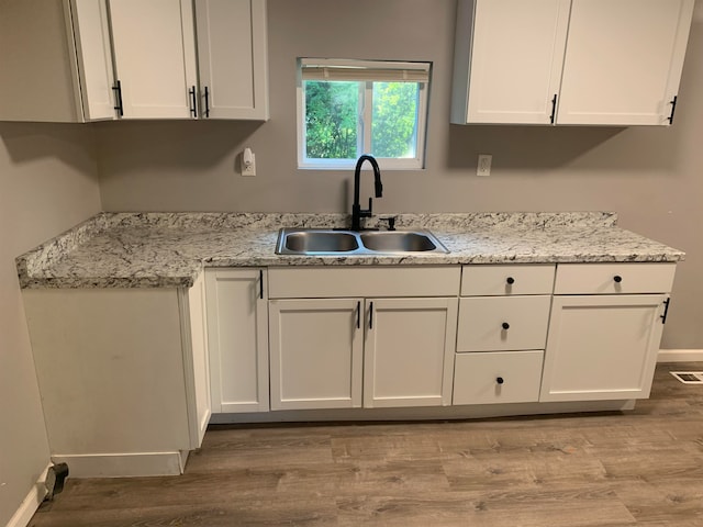 kitchen featuring white cabinets and sink