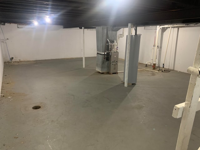 basement featuring water heater and heating unit