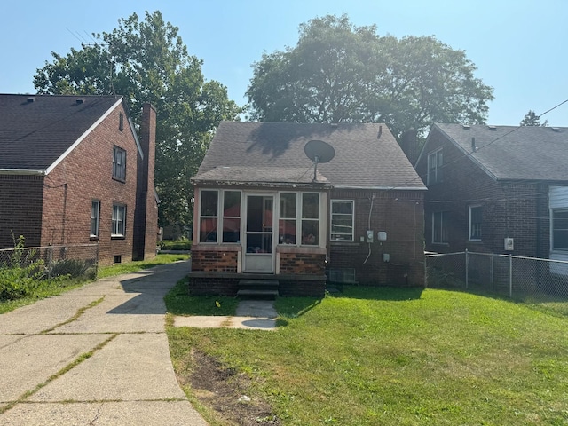 bungalow-style home with a sunroom and a front lawn