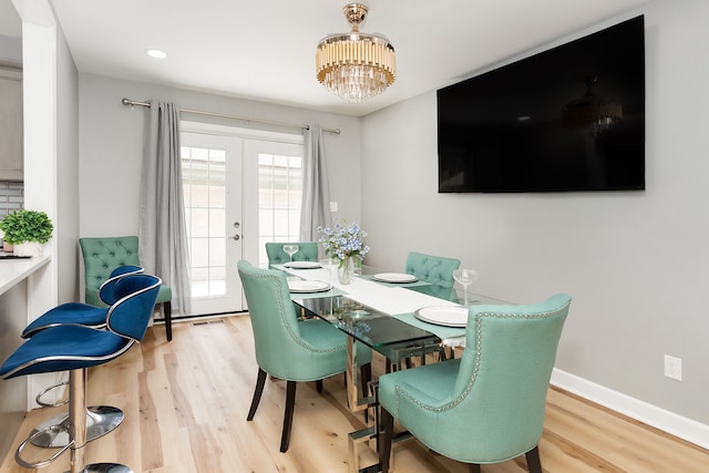 dining room with hardwood / wood-style floors, an inviting chandelier, and french doors