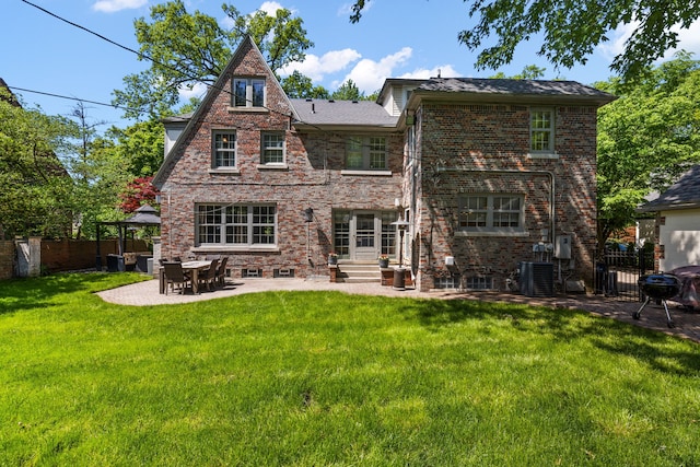 rear view of property featuring a yard, a patio, and central AC unit