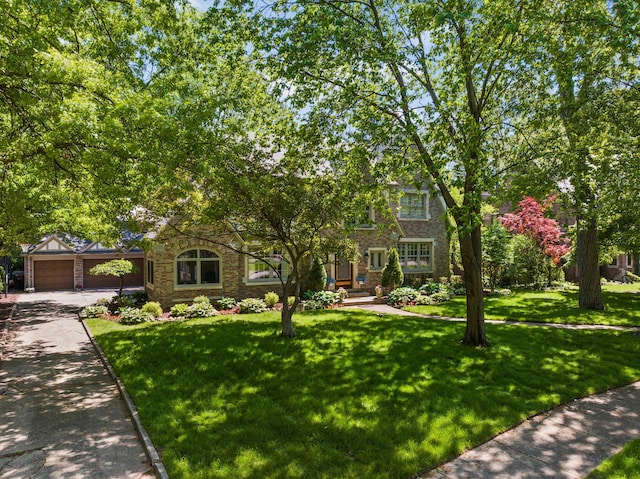 view of front of house with a garage, an outbuilding, and a front lawn