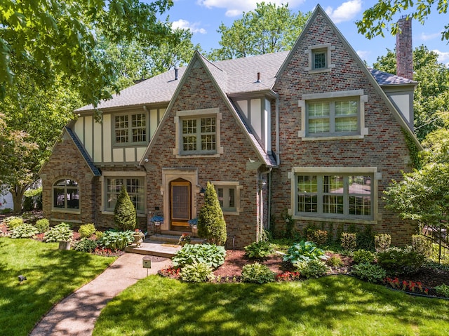 tudor-style house featuring a front lawn