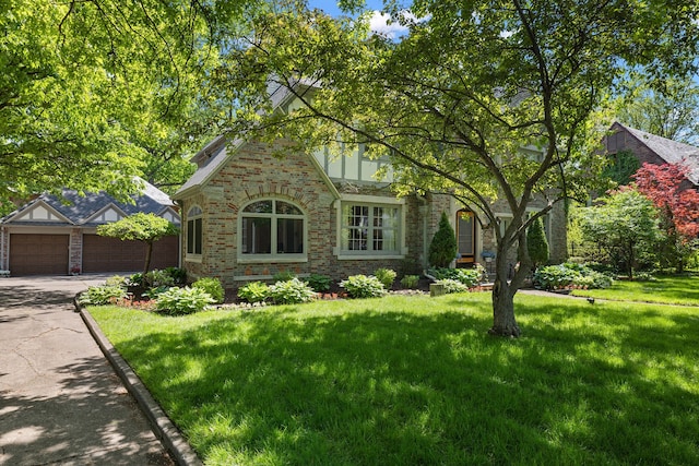 english style home with a garage and a front lawn