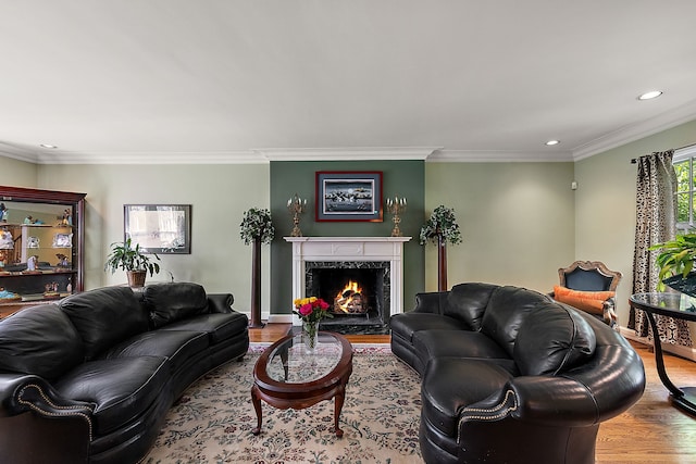 living room with a fireplace, light wood-type flooring, and ornamental molding