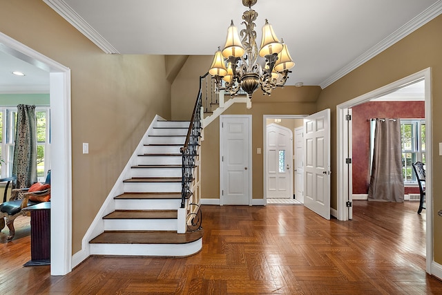 entrance foyer featuring crown molding, plenty of natural light, dark parquet floors, and an inviting chandelier