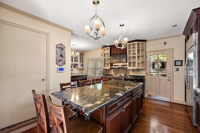 kitchen featuring a center island, dark hardwood / wood-style flooring, dark stone countertops, a chandelier, and decorative light fixtures