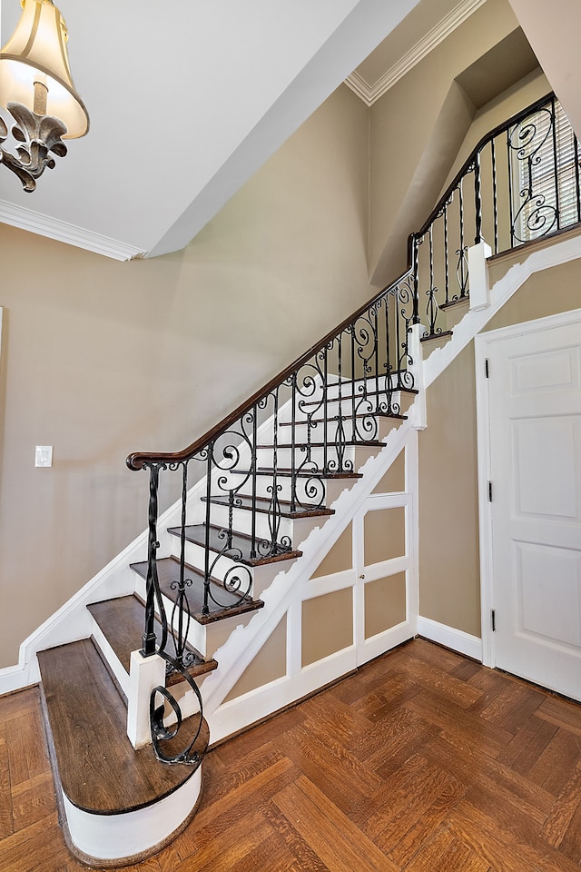 staircase featuring parquet floors and ornamental molding