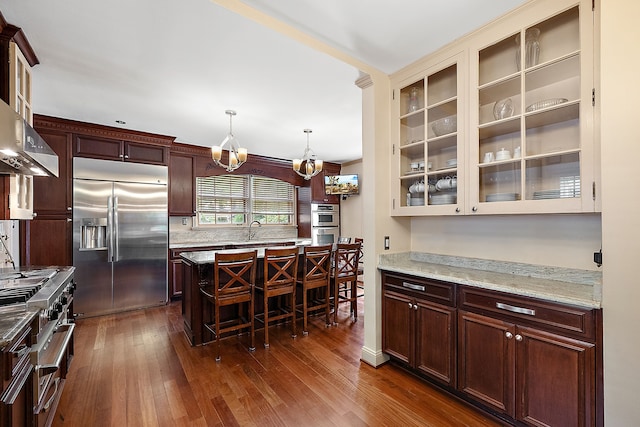 kitchen featuring a notable chandelier, dark hardwood / wood-style floors, high quality appliances, and decorative light fixtures