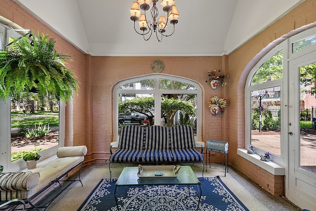 sunroom featuring a notable chandelier, a healthy amount of sunlight, and vaulted ceiling