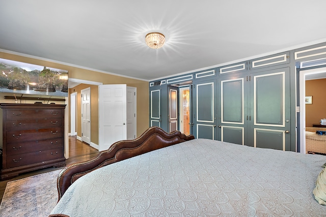 bedroom with dark hardwood / wood-style flooring and ornamental molding