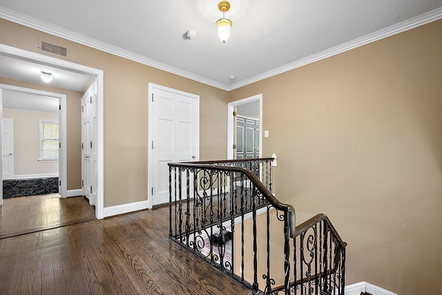 corridor with dark hardwood / wood-style flooring and ornamental molding