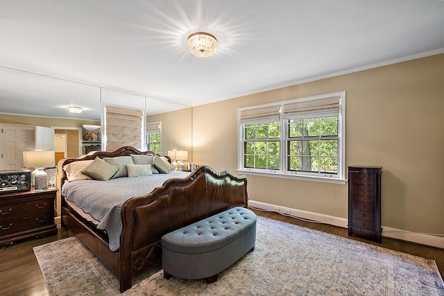 bedroom with dark hardwood / wood-style floors, multiple windows, and ornamental molding