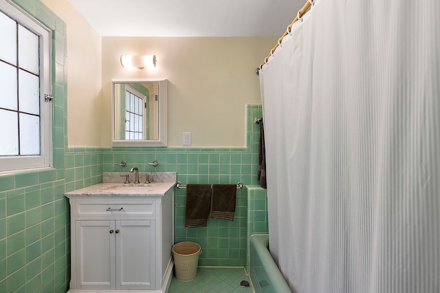 bathroom featuring tile patterned flooring, vanity, tile walls, and shower / bath combo with shower curtain