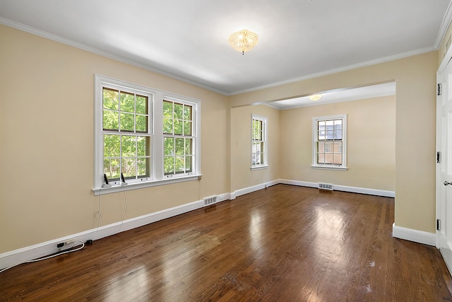 spare room with dark hardwood / wood-style floors, a healthy amount of sunlight, and crown molding