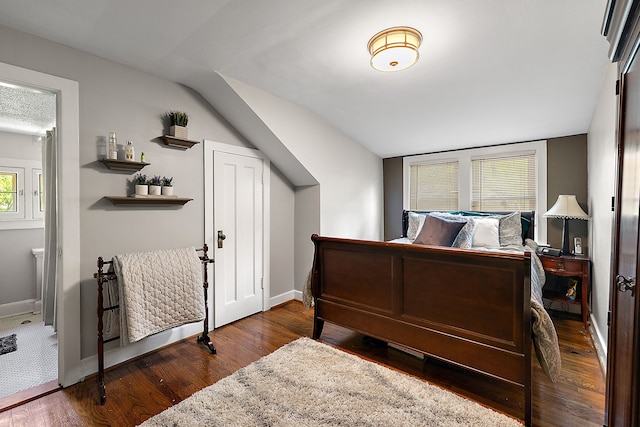 bedroom with dark hardwood / wood-style flooring and lofted ceiling