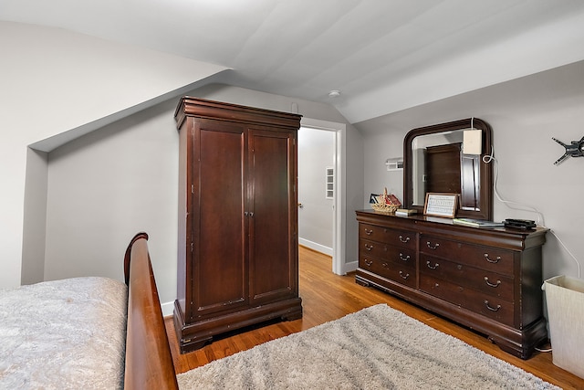 bedroom with light wood-type flooring and lofted ceiling