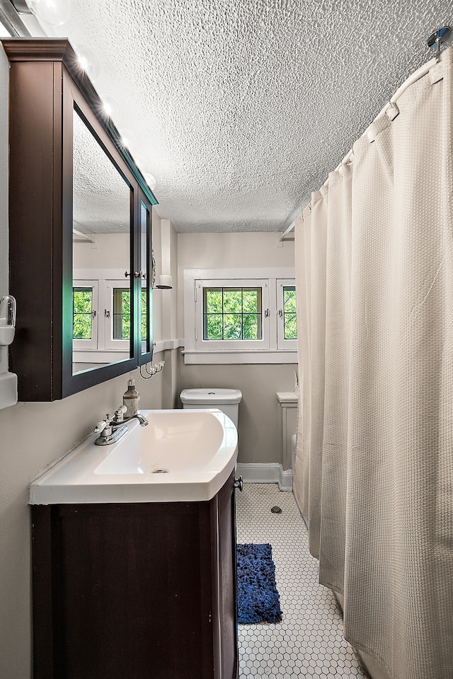 bathroom featuring tile patterned floors, vanity, and a textured ceiling