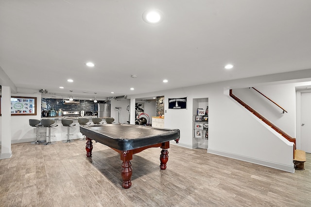 rec room with bar area, billiards, and light hardwood / wood-style flooring