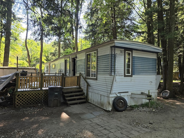 7867 W Wisconsin St, Shelby, MI 49455 - view of front facade featuring a deck and view of wooded area