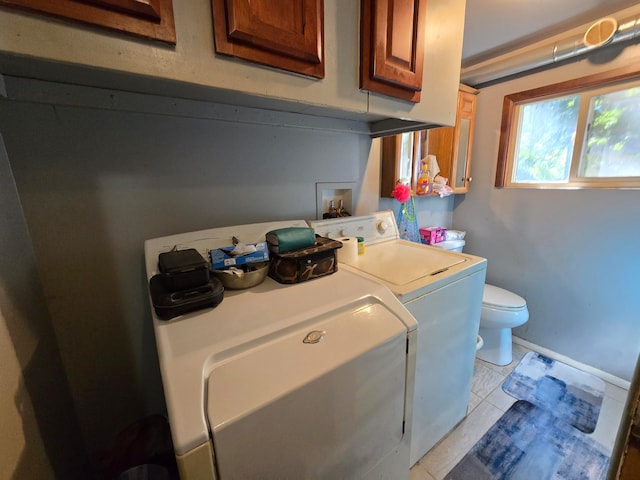 laundry area with separate washer and dryer and light tile patterned floors