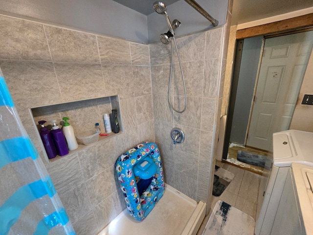 bathroom with tile patterned flooring, walk in shower, and washer / clothes dryer