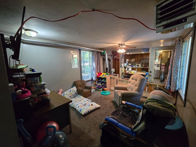 living room with carpet flooring, ceiling fan, and a textured ceiling