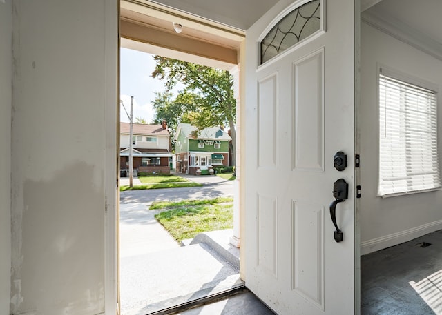 foyer entrance with crown molding and a wealth of natural light