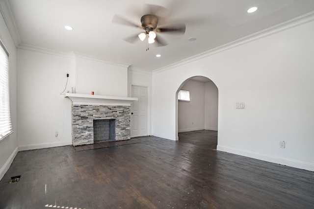 unfurnished living room with a stone fireplace, a wealth of natural light, and ornamental molding