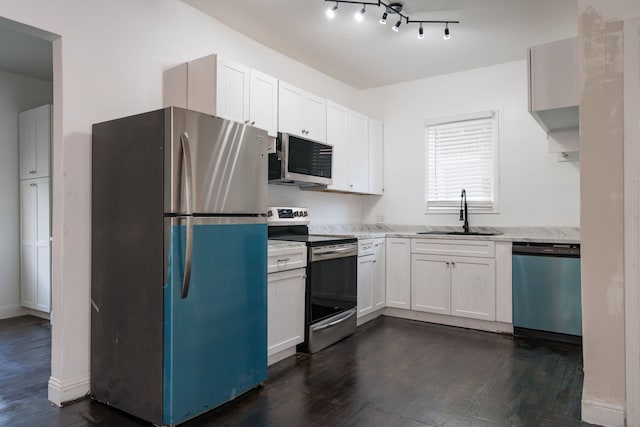 kitchen with light stone countertops, stainless steel appliances, dark wood-type flooring, sink, and white cabinetry