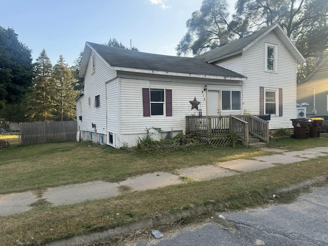 view of front of property with a wooden deck and a front yard