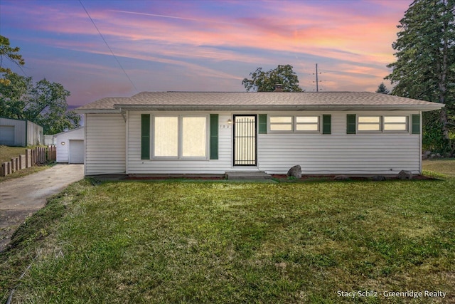 view of front of property with an outbuilding, a garage, and a lawn