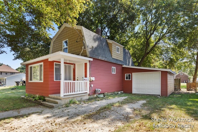 view of front of property featuring driveway, a shingled roof, a gambrel roof, an attached garage, and a front lawn