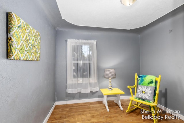 living area with wood finished floors and baseboards