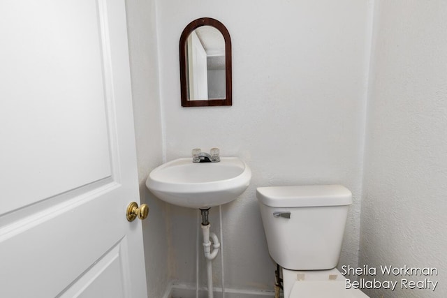 half bathroom featuring a sink and toilet