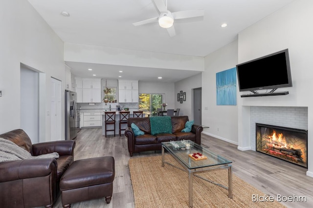 8981 Spruce Ave Unit B, Newaygo, MI 49337 - living room featuring light wood-style floors, a glass covered fireplace, ceiling fan, baseboards, and recessed lighting