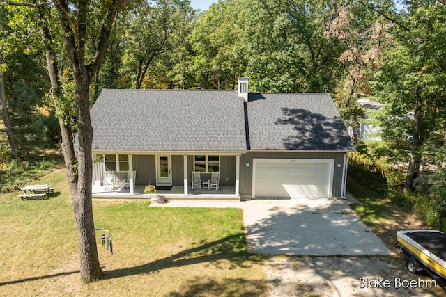 8981 Spruce Ave Unit B, Newaygo, MI 49337 - view of front of house with a porch, a garage, driveway, roof with shingles, and a front lawn