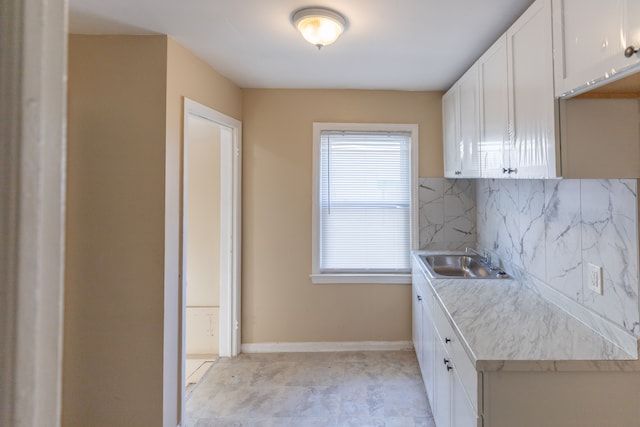 kitchen with white cabinets, decorative backsplash, and sink