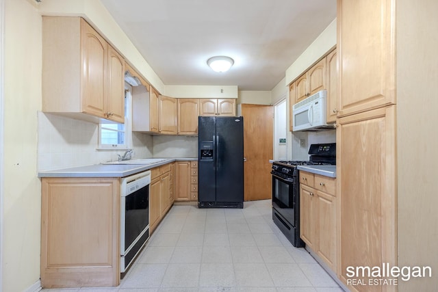 kitchen featuring black appliances, light brown cabinets, and sink