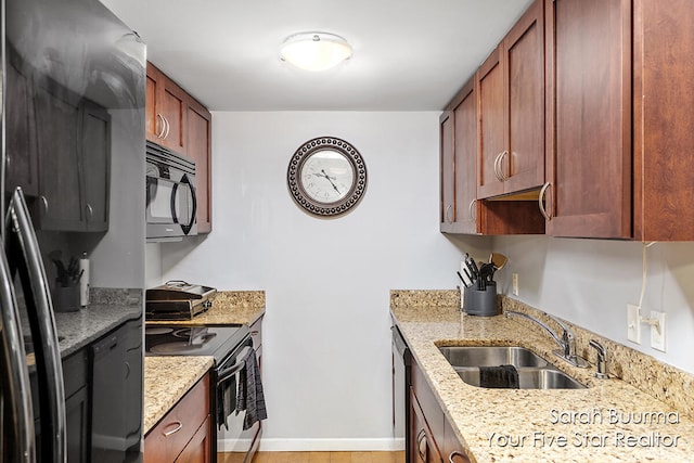 kitchen featuring light stone counters, sink, and stainless steel range with electric stovetop